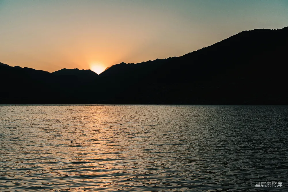 高清摄影  水边夕阳下的山的剪影
