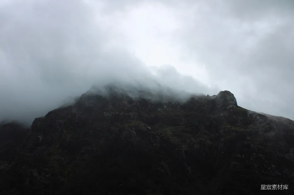 高清摄影  一座非常高的山，天空中布满了云层。