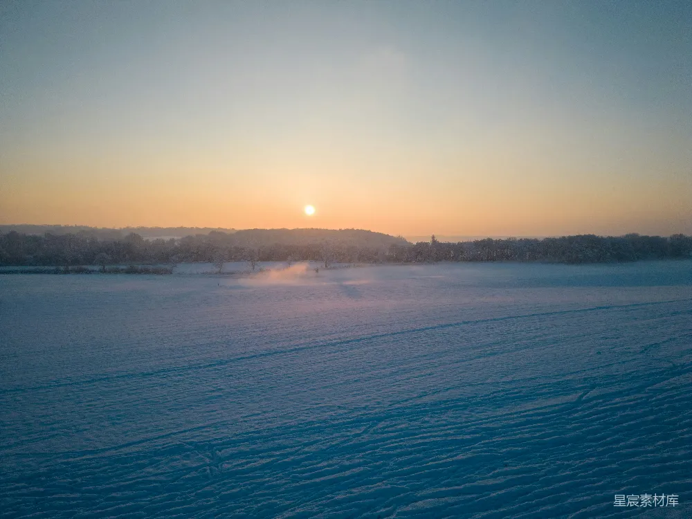 高清摄影  夕阳正在白雪覆盖的田野上落下。