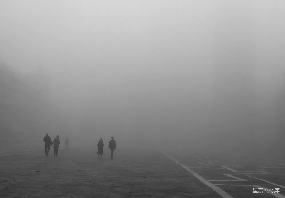 高清摄影  一群人在雾中沿着街道行走。