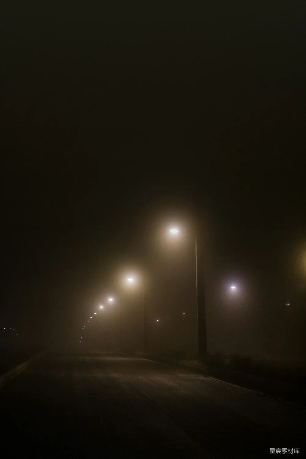 高清摄影  雾蒙蒙的街道上有街灯，在一个雾蒙蒙的夜晚。