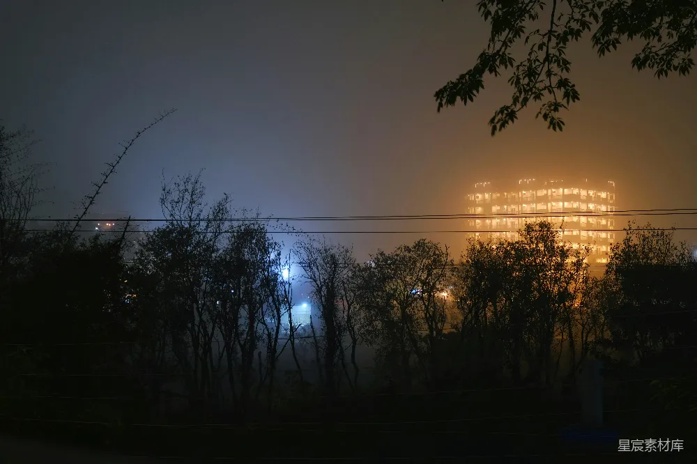 高清摄影  一个雾蒙蒙的夜晚，远处有一栋建筑。