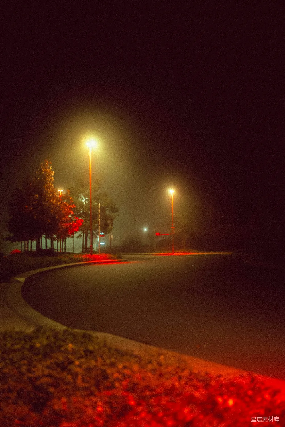 高清摄影  一条夜晚的黑暗街道，路灯亮着。