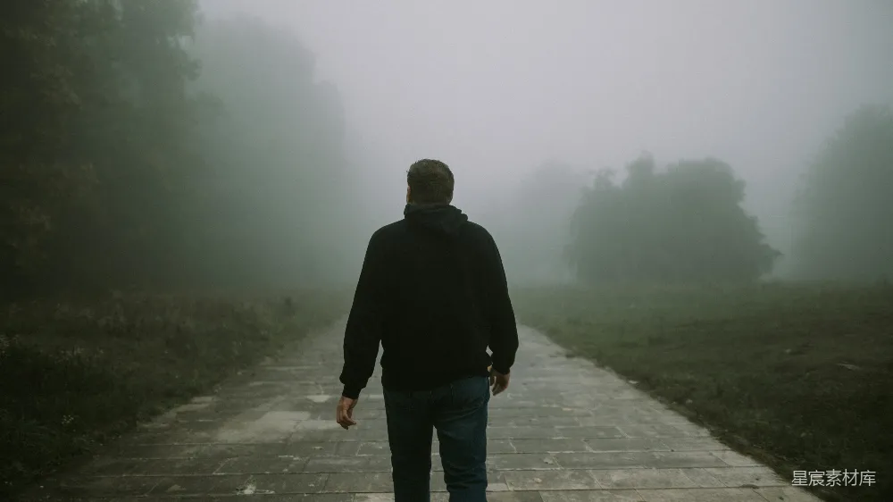 高清摄影  一个男人在雾中沿着小路行走。