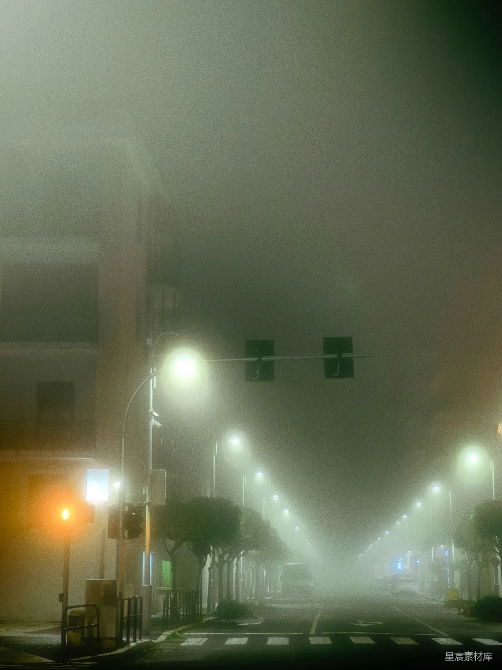 高清摄影  夜晚雾蒙蒙的城市街道，街道上有路灯。
