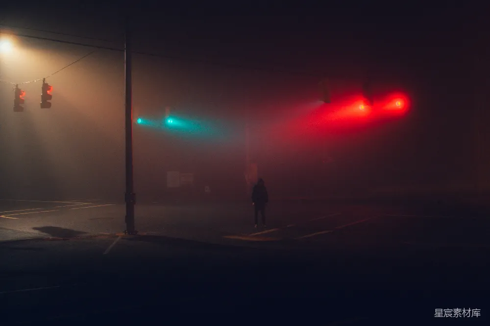 高清摄影  穿黑色夹克的男人站在人行道上，时间是夜间。