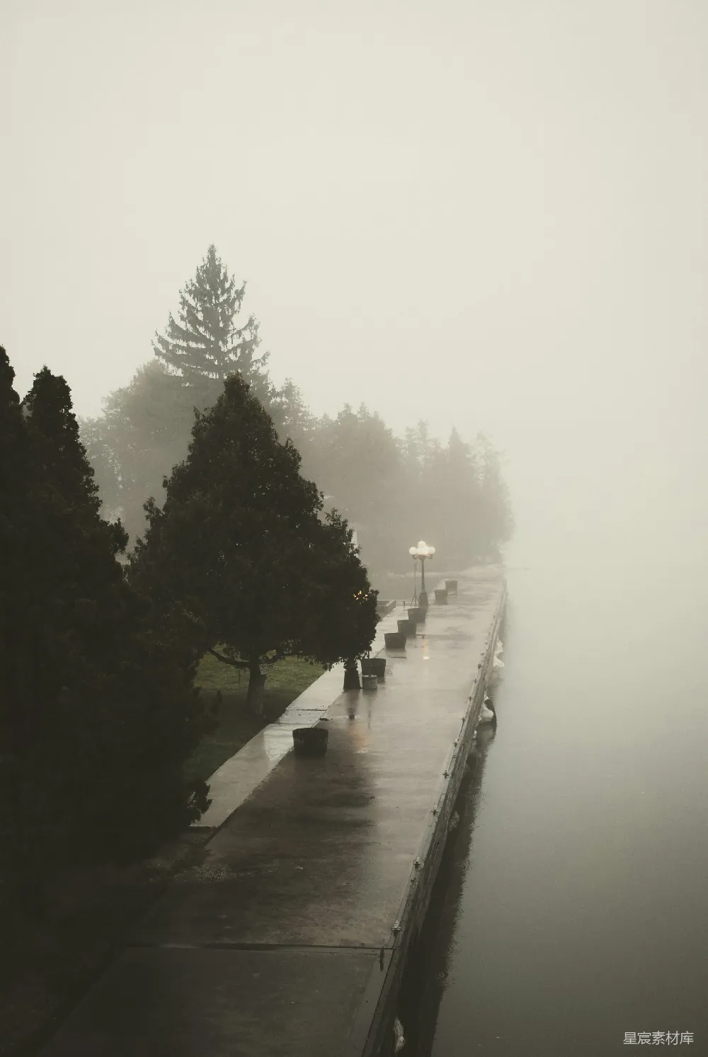高清摄影  人们在雨中沿着人行道行走