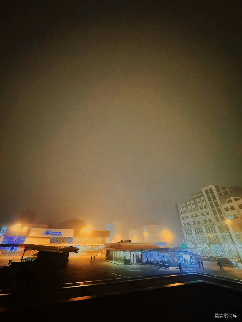 高清摄影  一个雾蒙蒙的夜晚，机场中有一座建筑物在背景中。