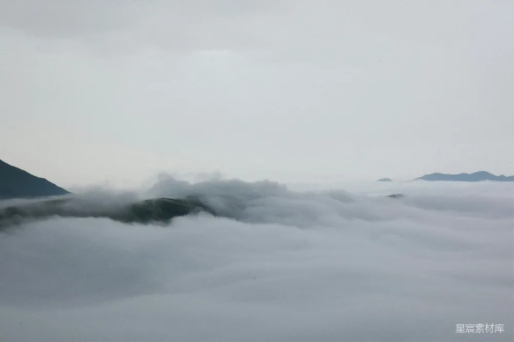 高清摄影 自然 山峦在薄雾笼罩的天空下被云层覆盖。