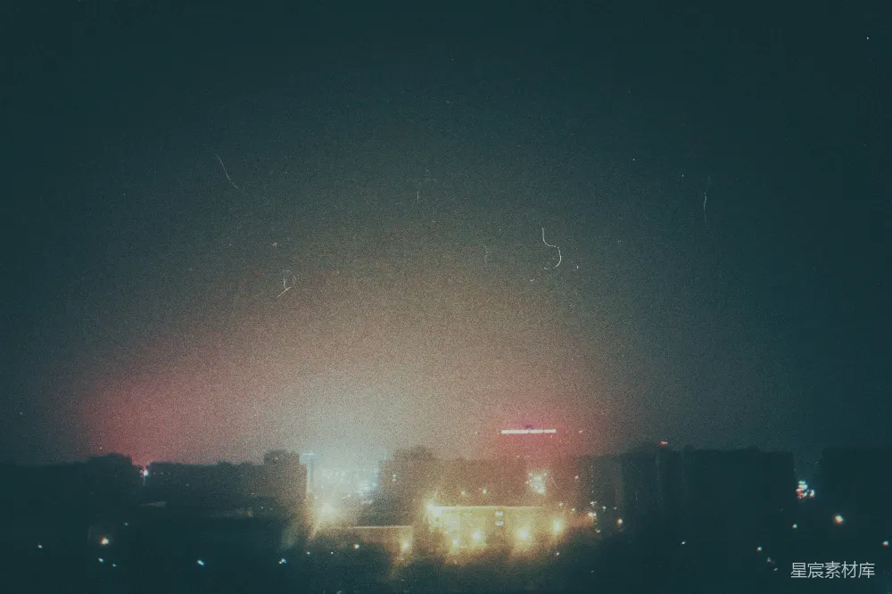 高清摄影  雾蒙蒙的夜晚城市景象，灯光闪烁，夜空漆黑。