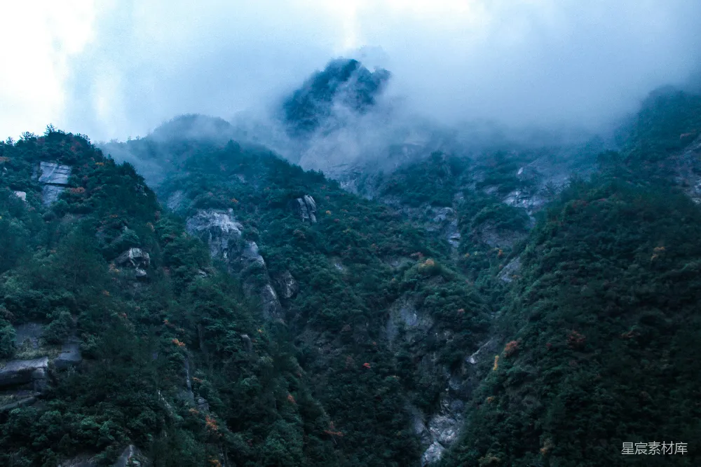 高清摄影  白天，山间白云下绿树成荫。