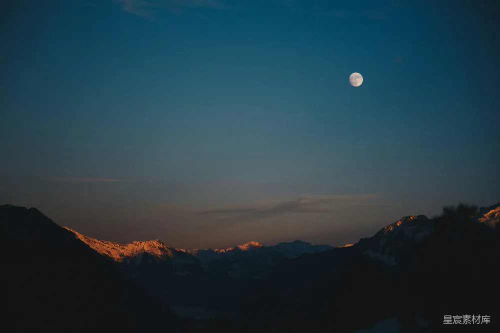 高清摄影  夜晚白雪覆盖的山峰与月亮