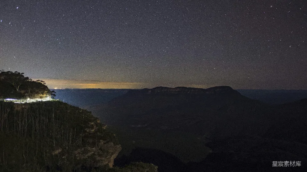 高清摄影  夜晚山间的景色，天空中有星星闪烁。