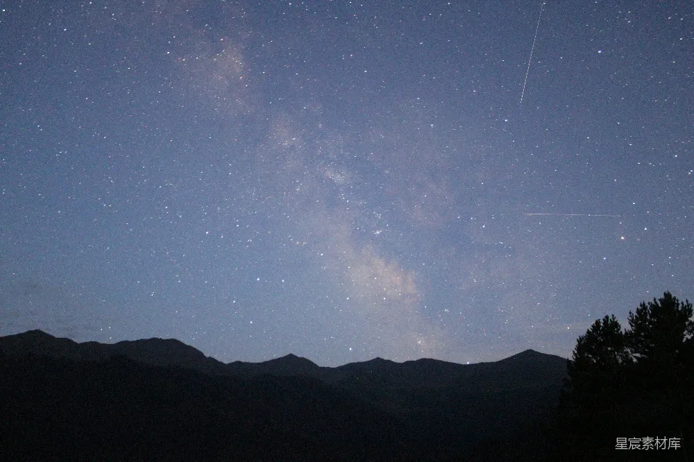 高清摄影 旅行 自然 夜晚蓝天下，山的剪影中点缀着星星。