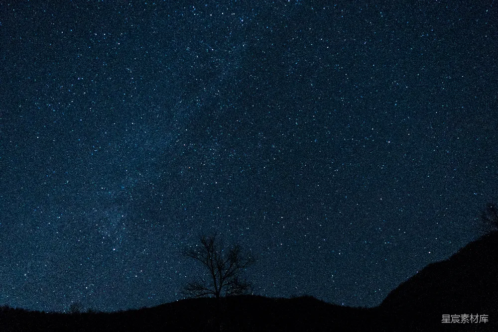 高清摄影  夜空中的星星在一座小山上空