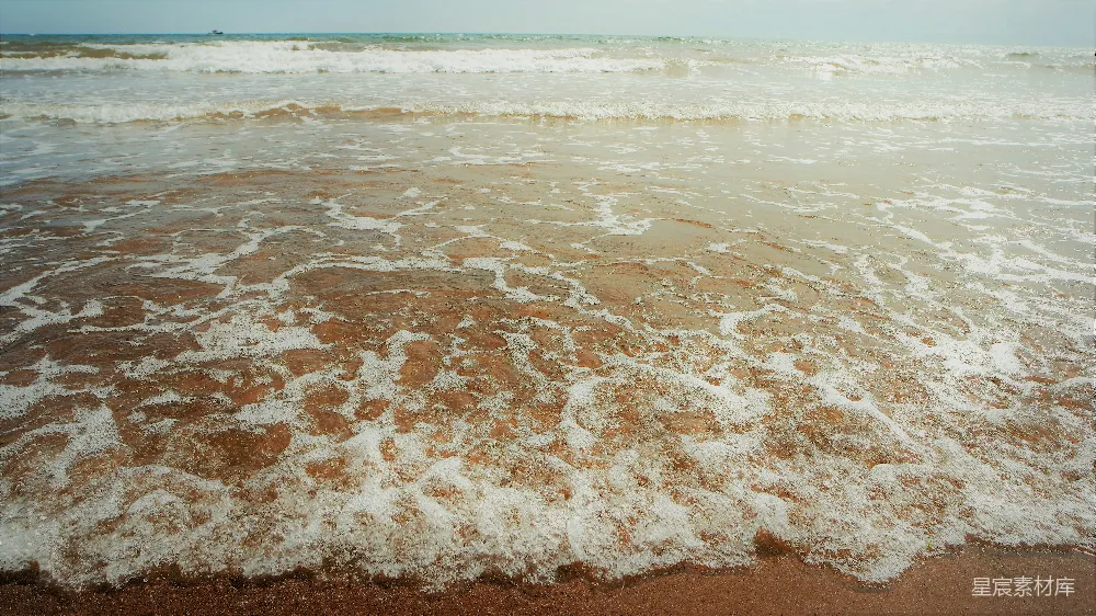 高清摄影  一个海滩，海水波浪不断进出。