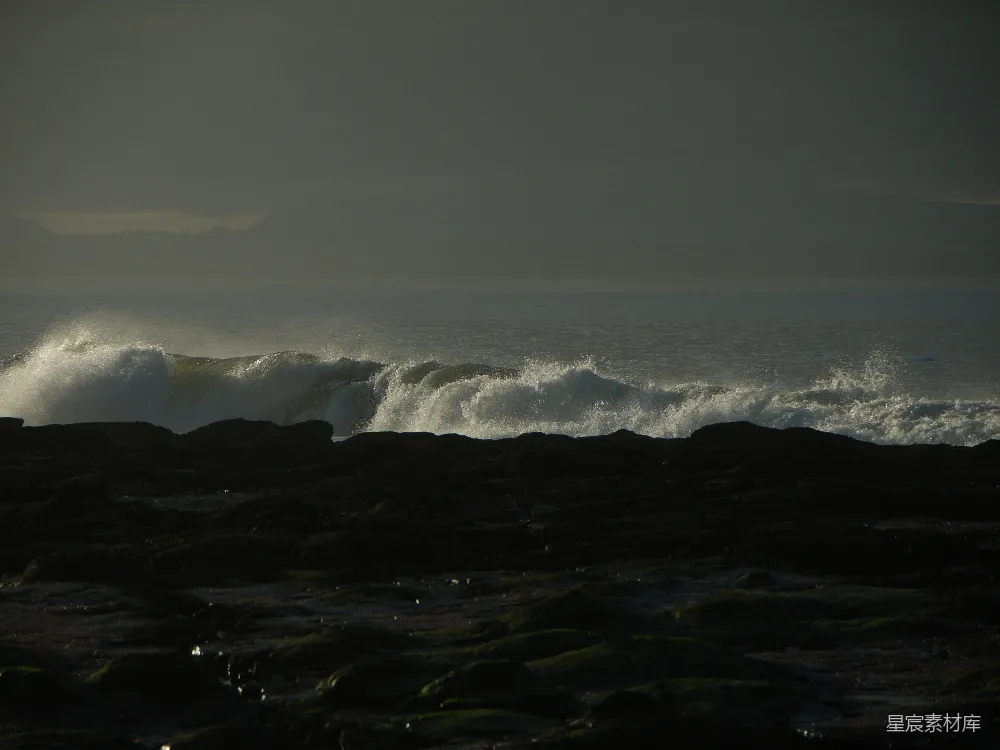 高清摄影  黄昏时分，海浪拍打着岩石海岸。