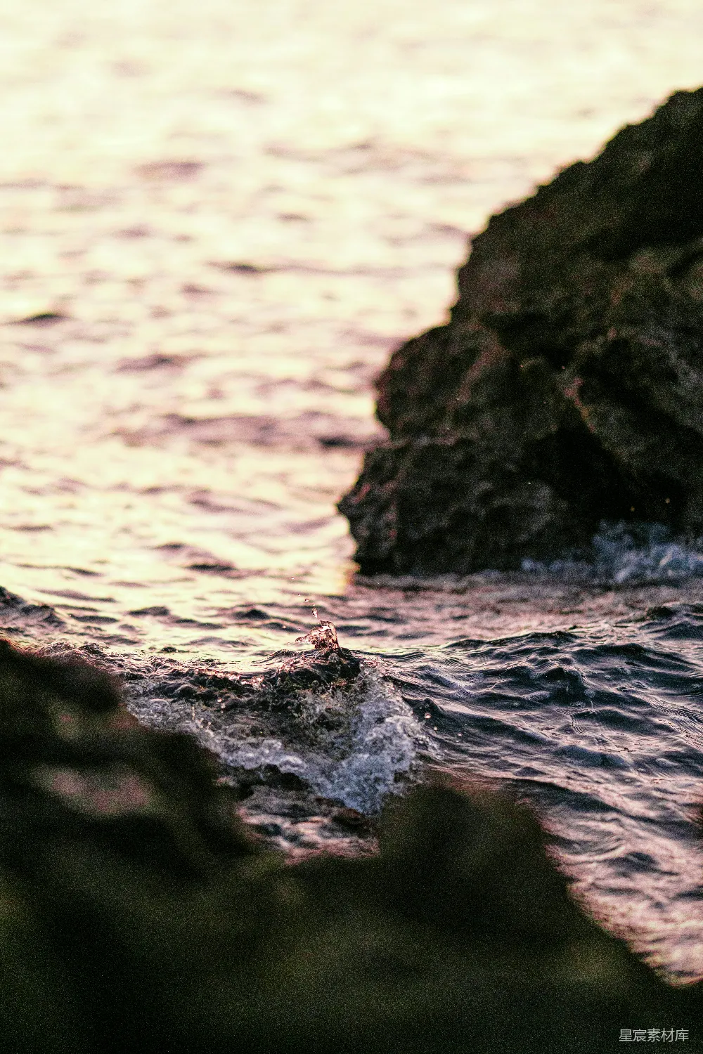 高清摄影  海浪在日落时拍打着岩石。