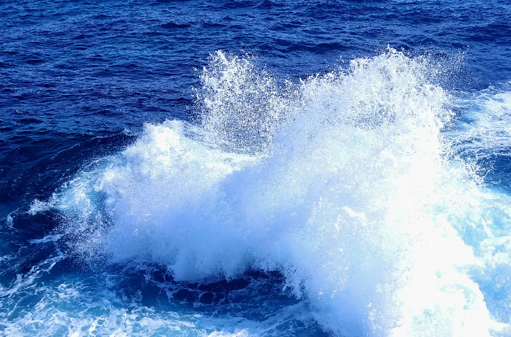 高清摄影  一股巨大的海浪冲向蓝色的海洋，激起白色的浪花。