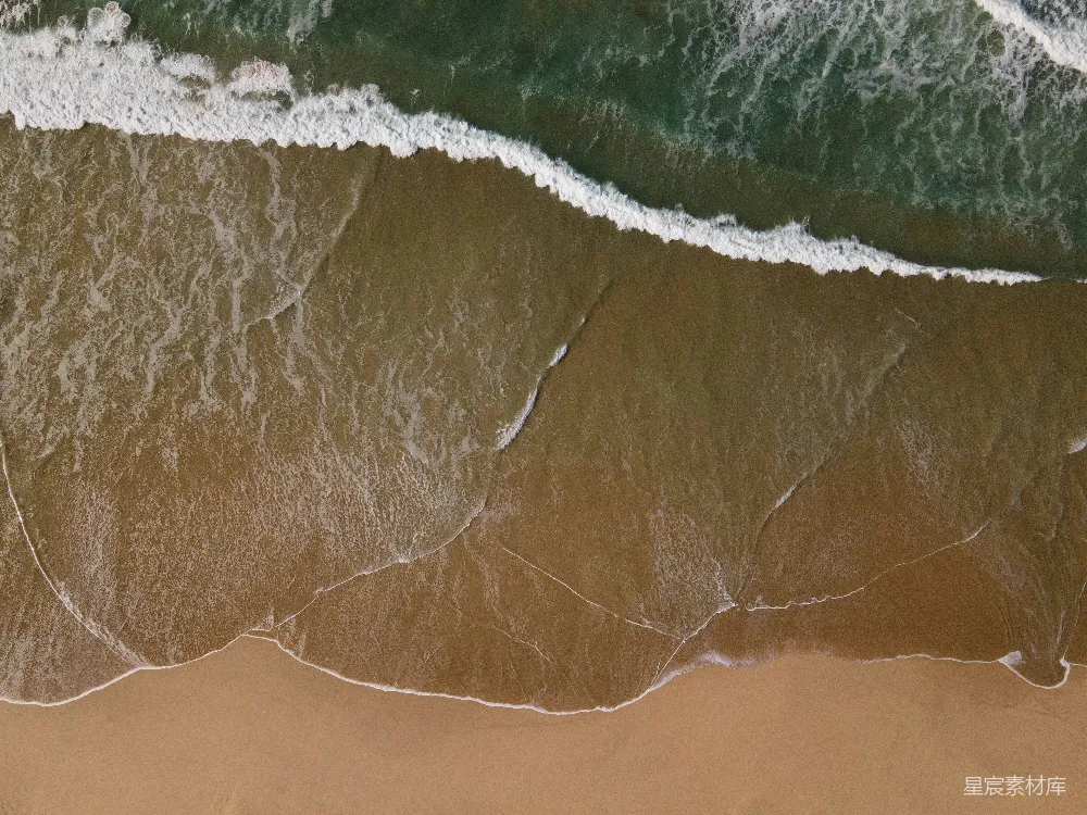 高清摄影  海滩的俯瞰图，波浪正向岸边涌来。