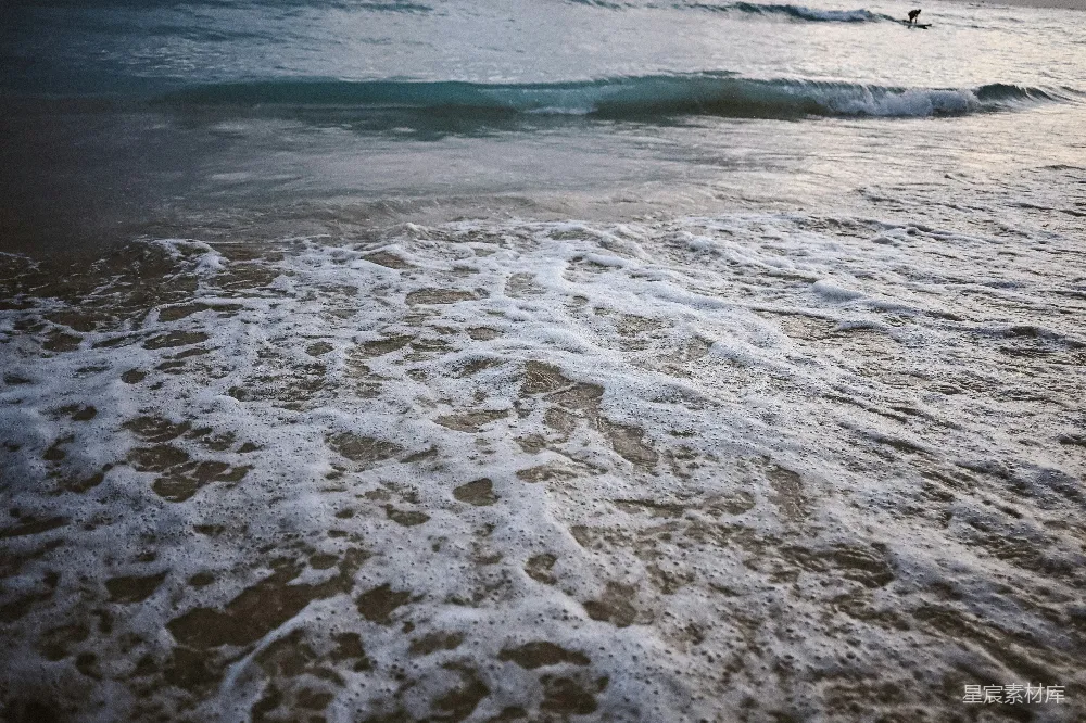 高清摄影  泡沫般的海浪拍打着沙滩。