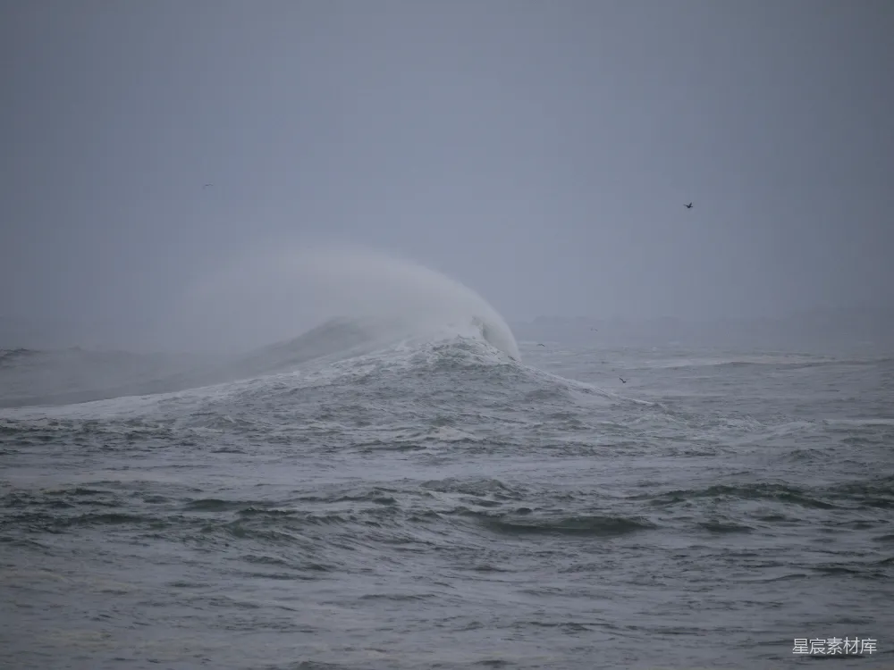 高清摄影  在暴风雨的大海中，一个巨大的海浪猛烈地冲击着。