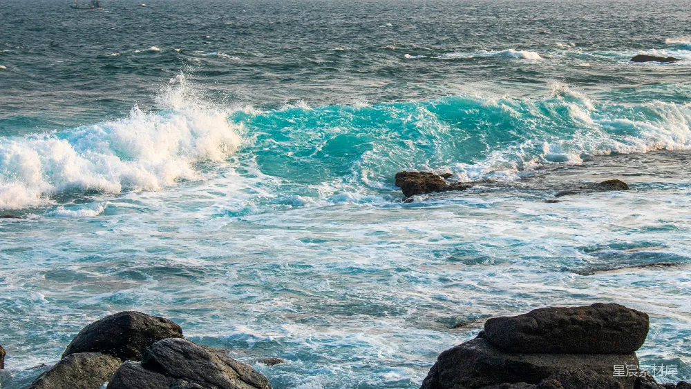 高清摄影  碧绿的海浪拍打在岩石海岸上。