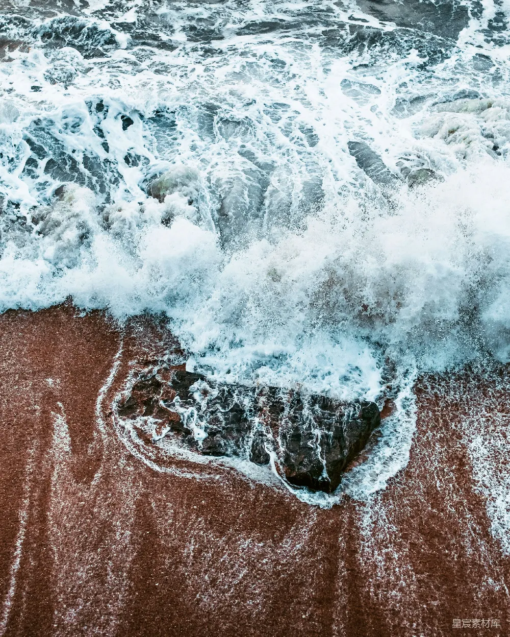 高清摄影  海浪拍打着棕色沙滩。