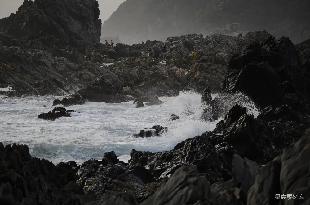 高清摄影  岩石海岸，海浪拍打着岩石。