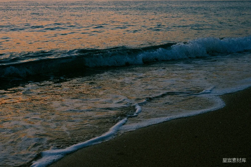 高清摄影  海滩上有海浪冲向岸边。