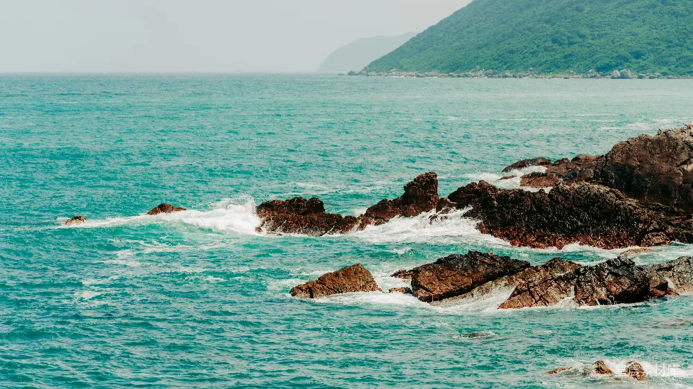 高清摄影  海浪拍打着岩石海岸，景色宁静。