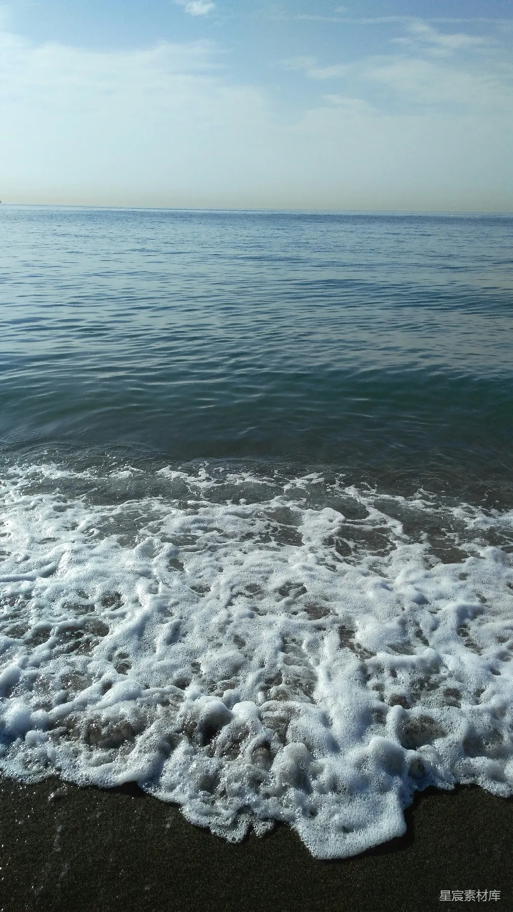 高清摄影  一个海滩，海浪正冲向岸边。