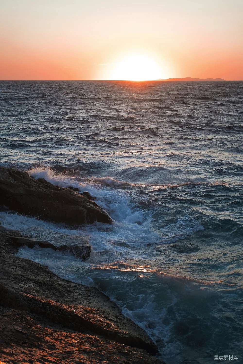 高清摄影  夕阳下，海浪拍打着岩石。