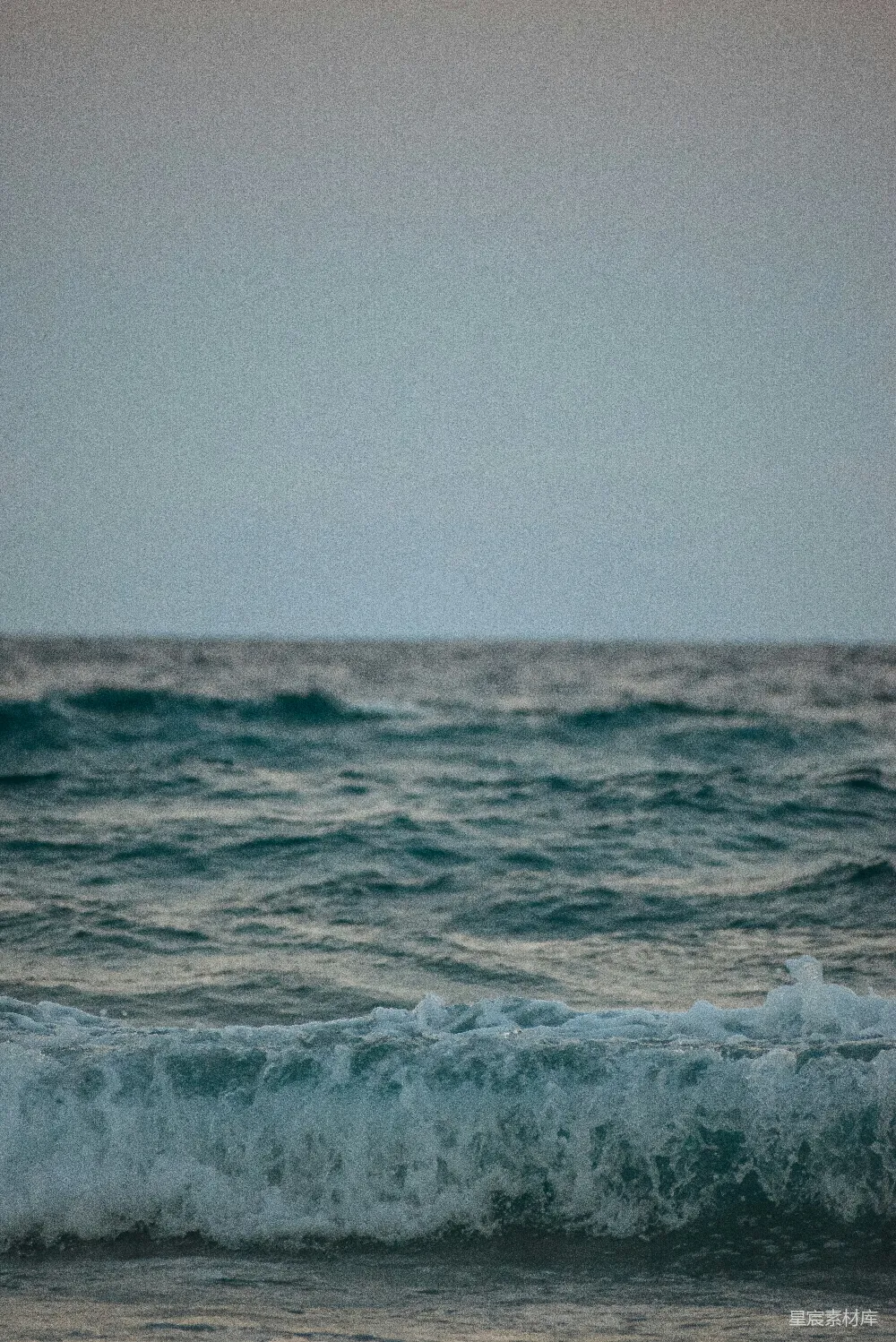 高清摄影  一个男人骑在冲浪板上，在海浪上滑行。