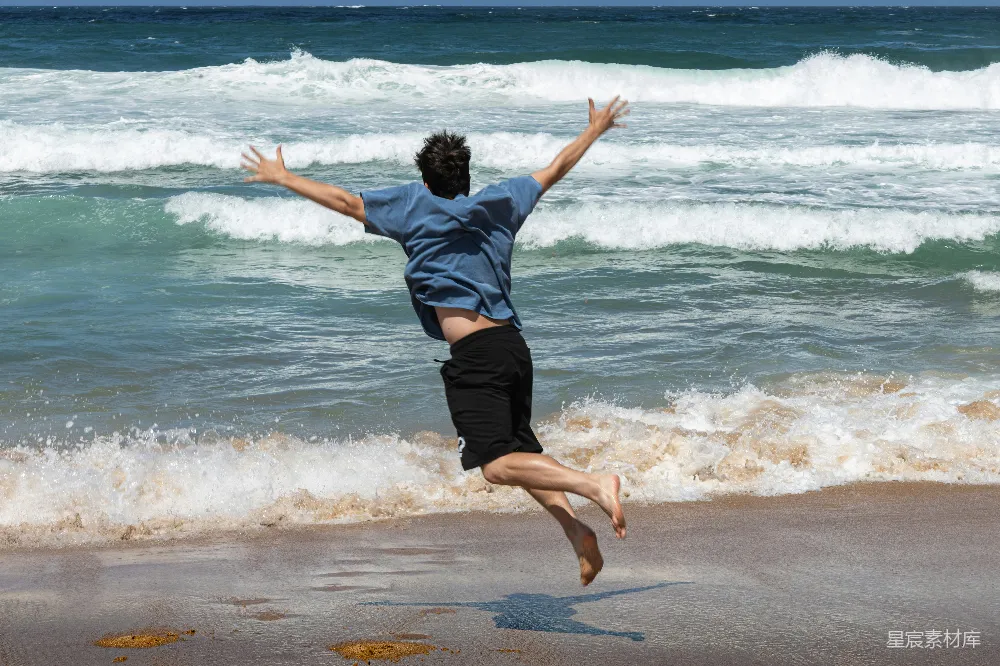 高清摄影 人物 男人在海滩上欢呼跳跃。