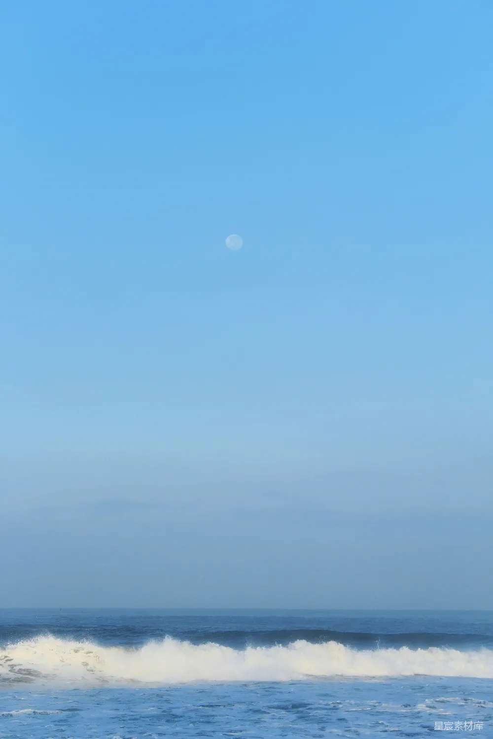 高清摄影  在海洋中的海浪上骑冲浪板的人