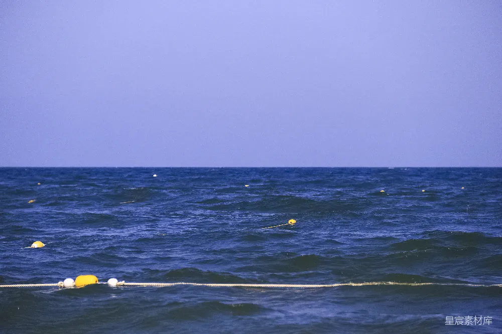 高清摄影  黄色的浮标漂浮在波涛汹涌的蓝色海洋上。