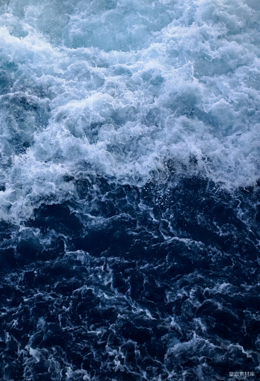 高清摄影  一个骑在冲浪板上的人在海浪上漂浮。