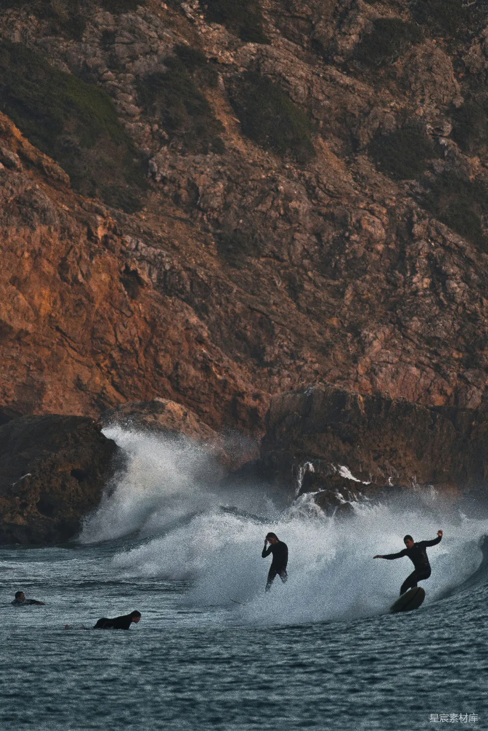 高清摄影  三名冲浪者正在海洋中冲浪。