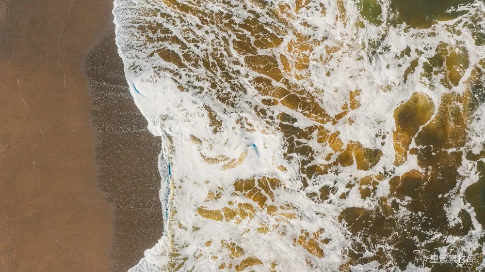 高清摄影  海滩上空的俯瞰图，海浪在岸边拍打着。
