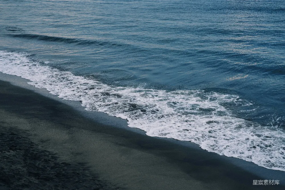 高清摄影  海浪拍打着黑暗的沙滩。