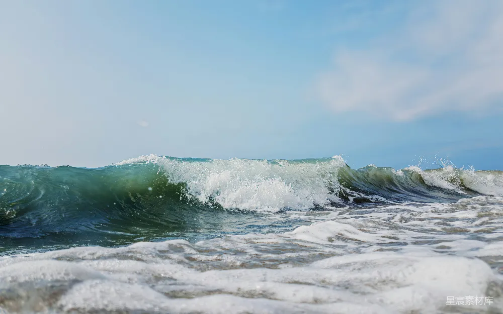 高清摄影 自然 壁纸 海浪拍打着沙滩，天空湛蓝。