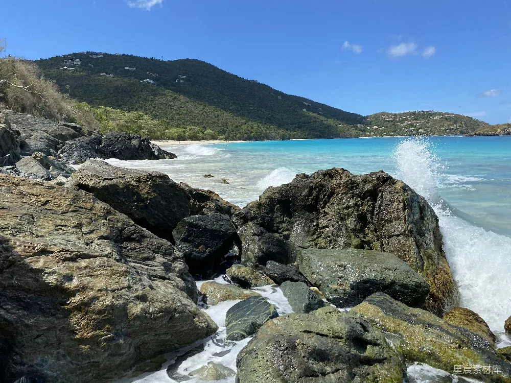 高清摄影  岩石海岸，远处有青山，天空湛蓝，白天景色。