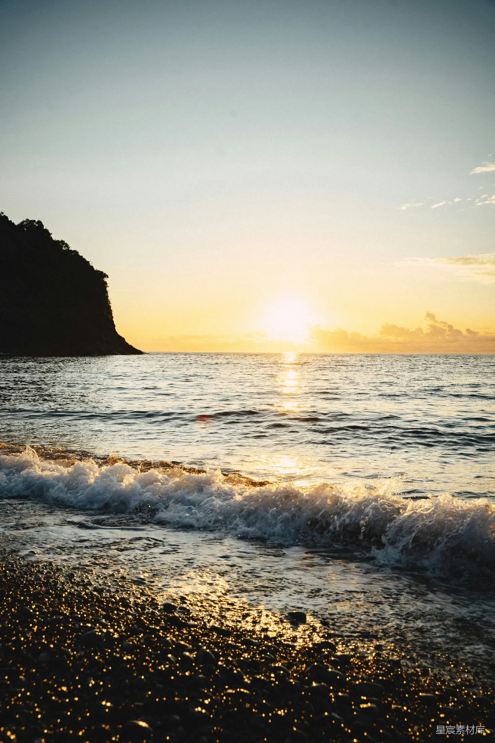 高清摄影  金黄的夕阳照耀着波涛汹涌的海浪和鹅卵石海滩