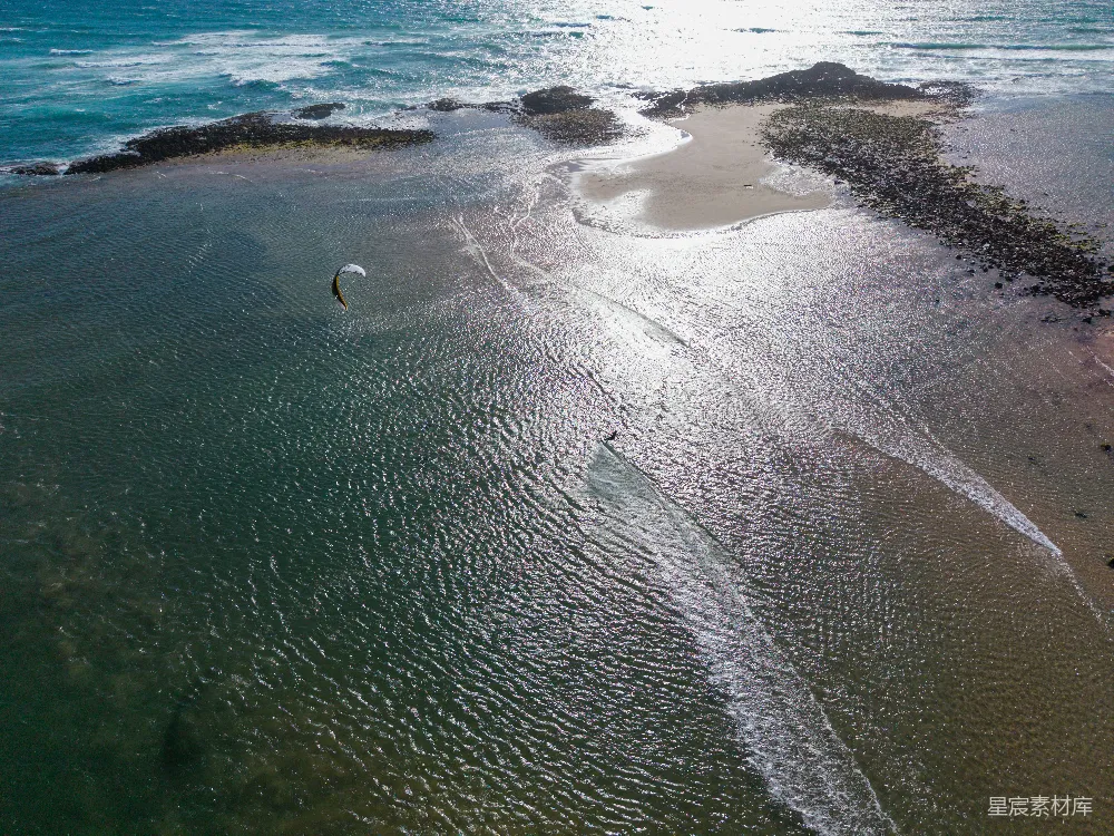 高清摄影  风筝冲浪者在岸边附近的浅海水中滑行