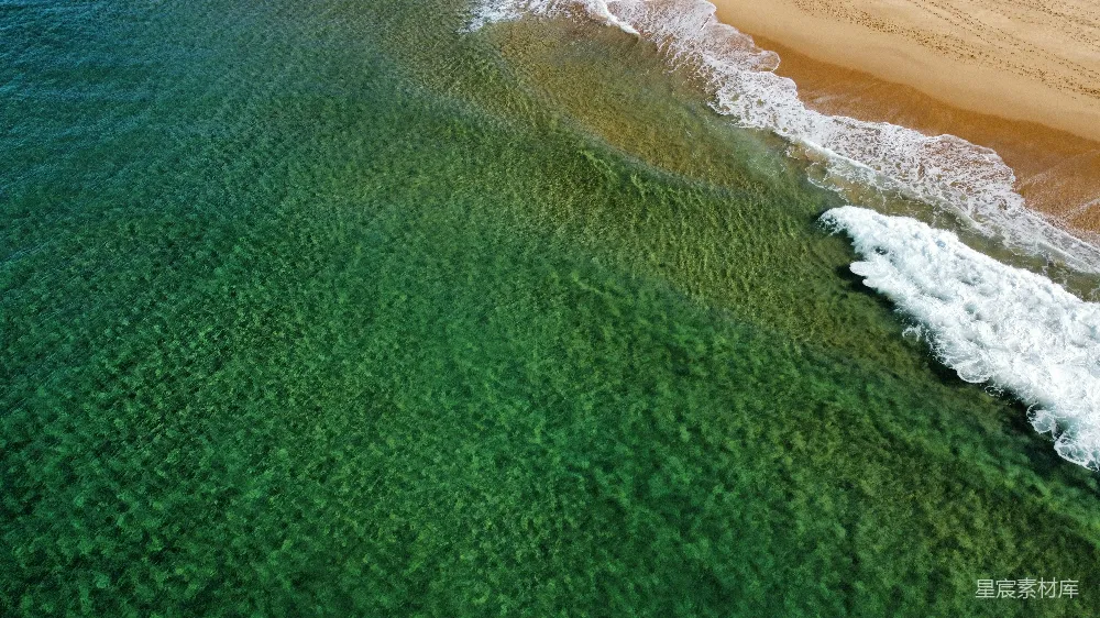 高清摄影  清澈的绿海水与白色的沙滩和白色的浪花相接。