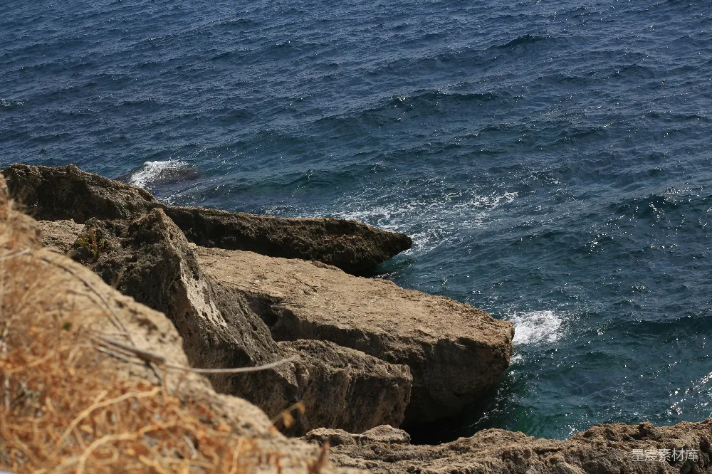高清摄影  白天的褐色岩石海岸与蓝色海水