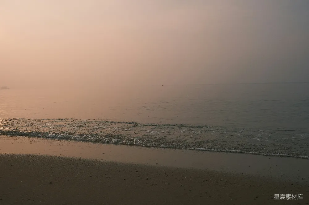 高清摄影  日出时分，柔和的海浪拍打着沙滩。
