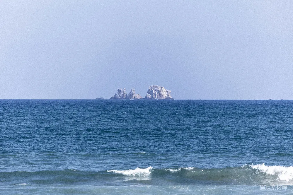 高清摄影  岩石岛从宁静的蓝色海洋中升起。