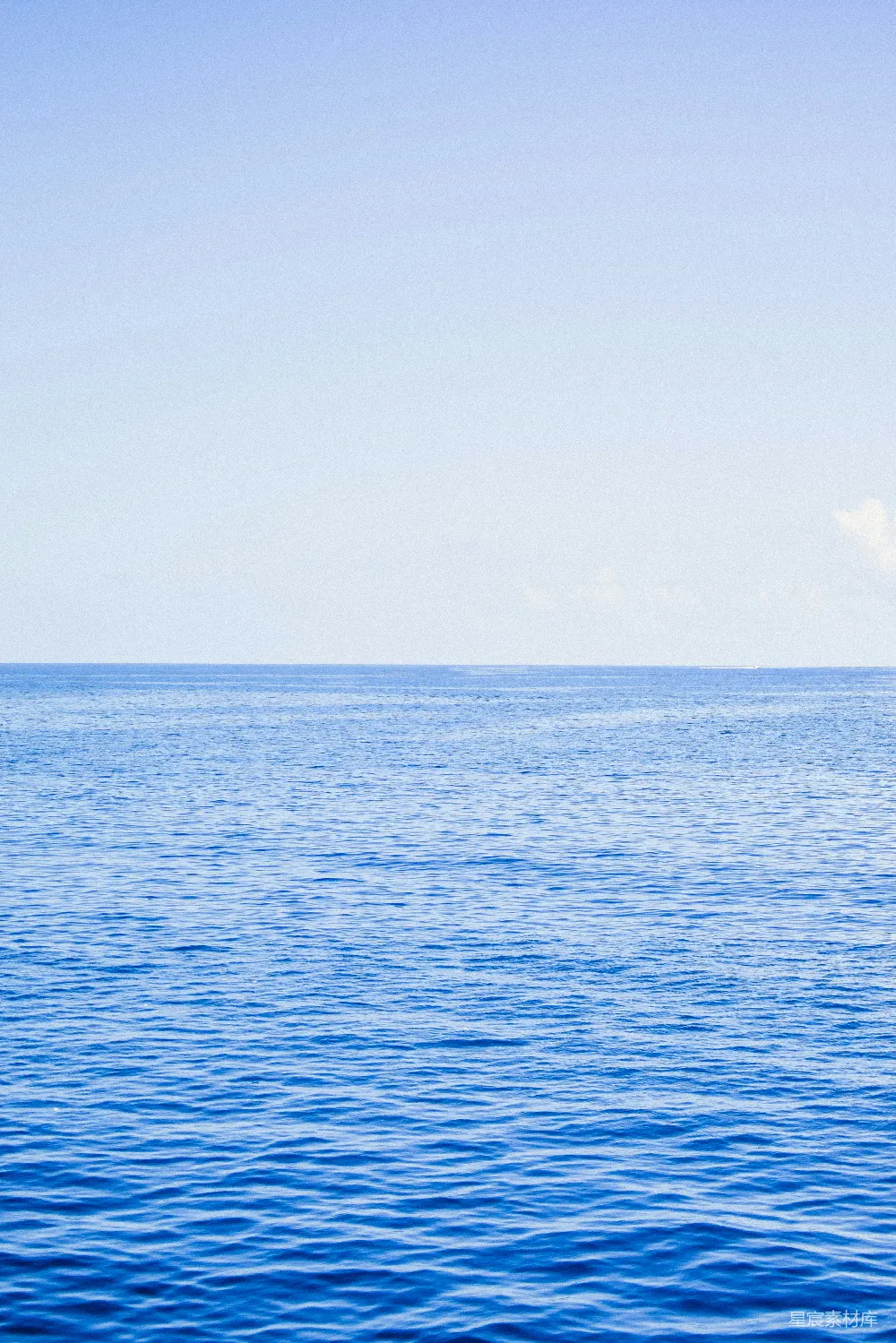 高清摄影  一片广阔的水域坐落在蓝色的天空下。